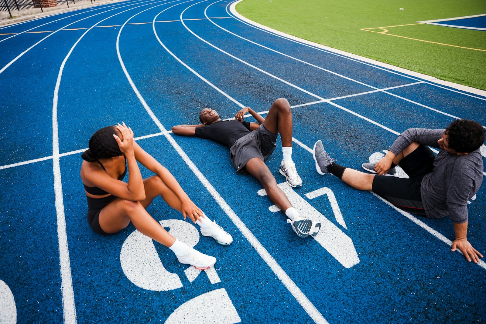 Athletes resting on a blue running track